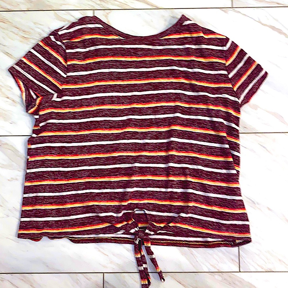 Burgundy blouse with tie on the bottom has red orange and white stripes across